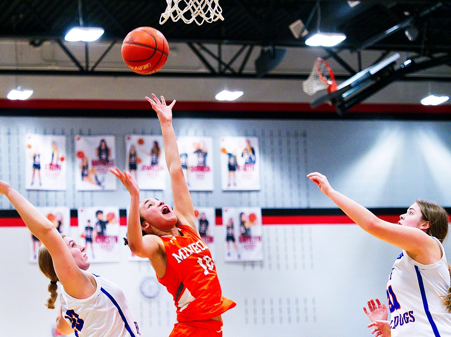 Jayla Jackson splits Bulldog defenders Annabelle Popek and Kaysi Parker to score two for Mineola. [see more shots, buy basketball photos]